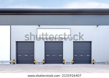 Three loading doors of an industrial warehouse Royalty-Free Stock Photo #2135926407