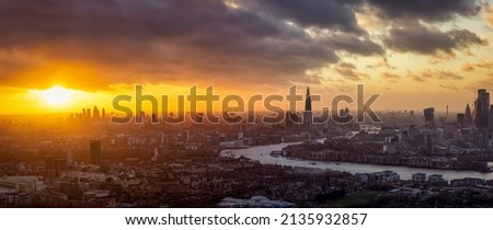 Wide, elavated panoramic sunset view of the urban skyline of London, England, with Thames river, the City and modern Skyscrapers