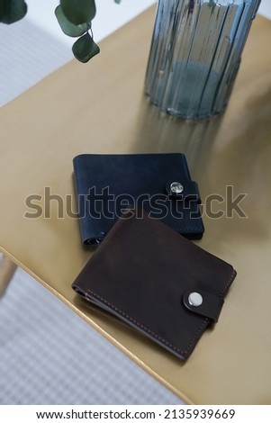 Leather wallet on a wooden and golden background.