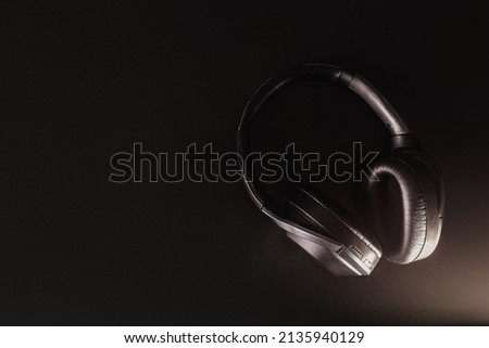Listening to music, social networks leads to relaxation. close up Headphone wireless product photo on black background, on table. Music online Enjoy listen Minimal, design for banner,Copy space object