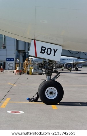 BOY sign on the hatch of an aircraft. Vertical photo with a fragment of an airplane at the airport. Congratulations on the birth of a boy.