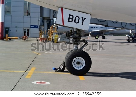 Horizontal photo with a fragment of an airplane at the airport. Congratulations on the birth of a boy. BOY sign on the hatch of an aircraft. Airplane travel concept. Air adventure. Chassis wheel.