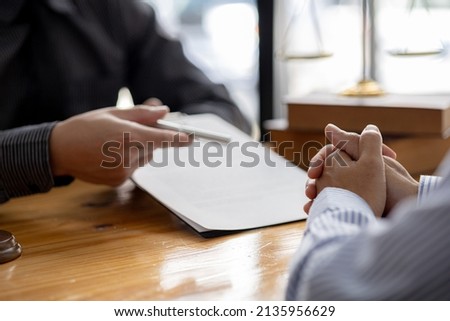 Client was listening to a lawyer advising on an embezzlement case, explaining the details of the proceeding and gathering evidence to file a lawsuit against the defendant. The concept of litigation. Royalty-Free Stock Photo #2135956629