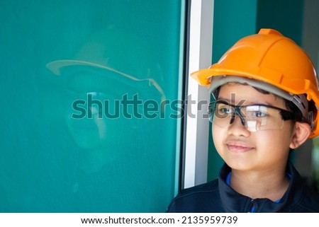 Asian boy dressed as a craftsman and holding tools	