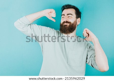 Handsome hipster bearded dancing and celebrating for something. Young man attitude funny. Blue tone color background, expression of normal people. Mockup concept with people