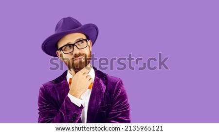 Pensive man performer in jacket and hat isolated on purple studio background look at blank copy space. Male entertainer in suit think over good sale deal or offer. Empty ad space. Copyspace. Royalty-Free Stock Photo #2135965121