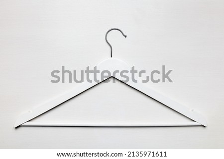White Wooden empty coat hanger with metal hook top view white wooden table background