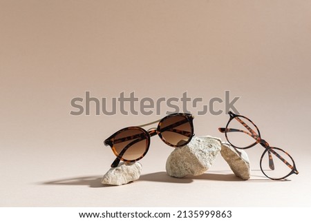 Sunglasses and glasses sale concept. Trendy sunglasses on beige background. Trendy Fashion summer accessories. Copy space for text. Summer sale. Optic store discount poster. Minimalism Royalty-Free Stock Photo #2135999863