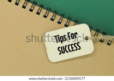 notebooks and wooden tags with the words tips for success