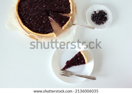 Sweet sliced cake with black currant. Homemade pie with summer berries on a white table.Top view from above. Tasty baked sweets. 