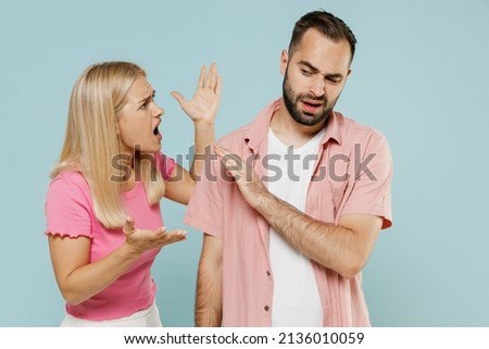 Young arguing sad couple two friends family man woman 20s in casual clothes screaming scolding together isolated on pastel plain light blue color background studio portrait People lifestyle concept Royalty-Free Stock Photo #2136010059
