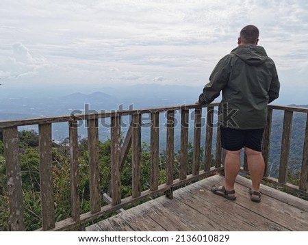 man hiker on top of a mountain enjoying view.