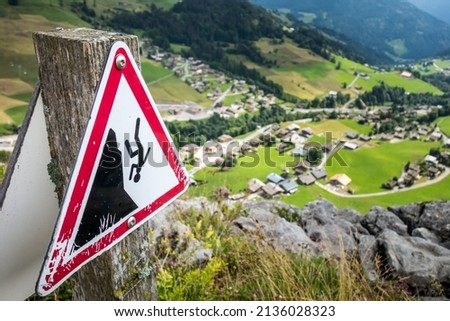 Fall danger warning sign near a high cliff