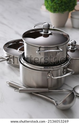 Set of new clean cookware and kitchen utensils on white marble table Royalty-Free Stock Photo #2136053269