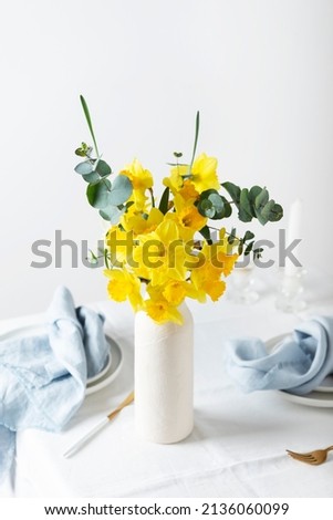 Concept of romanitic Easter table with flowers and white tablecloth, selective focus image