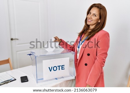 Young latin woman smiling confident voting at electoral college