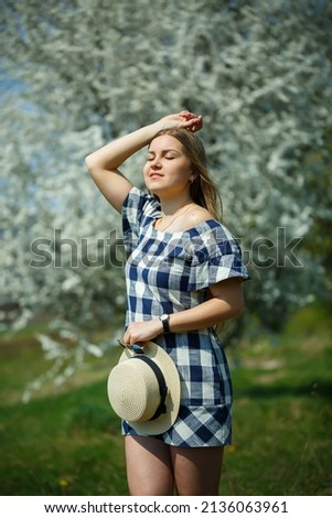 beautiful girl in a dress walking in the spring forest where the trees bloom