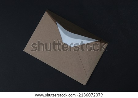 A small brown envelope isolated on a black background. Love Letter