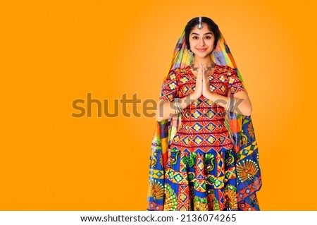 Beautiful indian race woman wearing national dress on orange background with copy space.