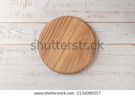 round cutting board on a white wooden table. mockup of a food background with copy space, top view