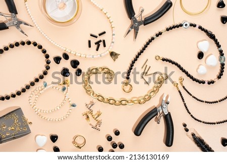 Tools and accessories for DIY jewelry in the workplace. Flat lay on beige background. Creative flat lay composition, top view. DIY craft workshop, homemade business. Making handmade for friends gifts