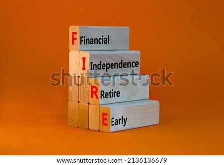 FIRE financial independence retire early symbol. Concept words FIRE financial independence retire early on blocks. Orange background. Business FIRE financial independence retire early concept. Royalty-Free Stock Photo #2136136679