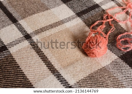 a ball of yarn for knitting on a plaid plaid
