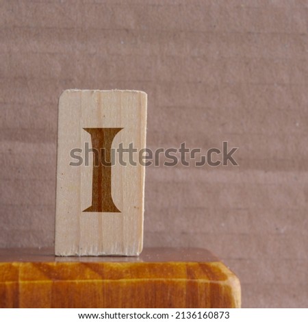 close-up shot of a wooden piece with a Norse rune engraved on it, specifically the isa character