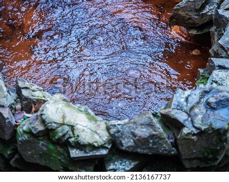 The pool with a rusty bottom is filled with gurgling mineral water. Valley of the Narzans. Selective focus.