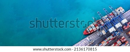 Aerial top view over international containers cargo ship at industrial import-export port prepare to load containers with big container loader ship vessel. global transportation and logistic business. Royalty-Free Stock Photo #2136170815