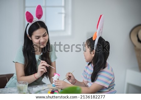 easter celebration concept with family at home, mom and her child or sister are happy and enjoy in holiday with rabbit tradition funning event