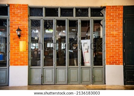 Outdoor mock up of store and shop front template - front view vintage black grey shop tone with windows display, and orange brick wall.