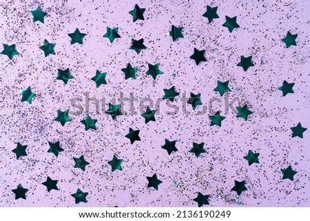 Seamless pattern with blue stars sequins on a purple background. Horizontal photo. Wallpaper, texture, background for your design and copy space.