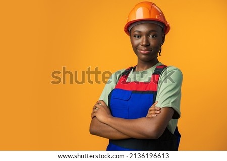 Young african american woman wearing architect hardhat against yellow background Royalty-Free Stock Photo #2136196613