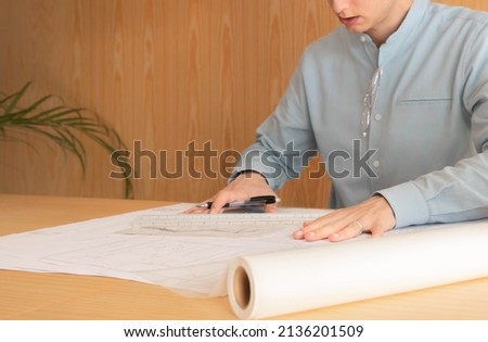 Close up of unrecognizable young man drawing on tracing paper wearing blue shirt Royalty-Free Stock Photo #2136201509