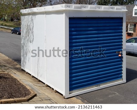 Temporary storage unit at curbside in residential neighborhood. Royalty-Free Stock Photo #2136211463