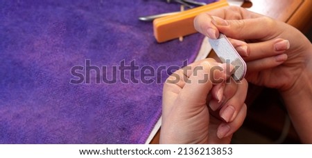 The process of grinding nails with file. Close-up. The process of self-manicure. Image for beauty websites. Selective focus.