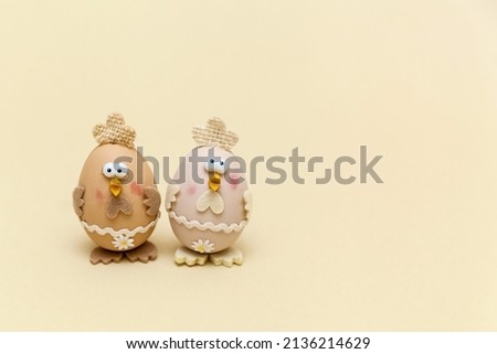 Concept of traditional Easter symbols. Cute chickens from eggs on beige background