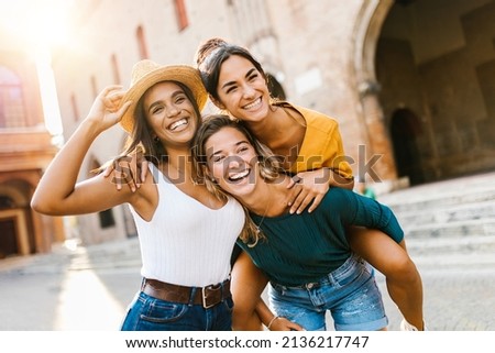 Multiethnic group of three happy young women having fun on summer vacation - Diverse female friends laughing together during their holidays - United people concept - Focus on african woman face Royalty-Free Stock Photo #2136217747