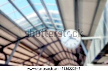 blurry view of analog clock in the sky train station or train platform in Bangkok, Thailand. interior ceiling of train platform showing sky windows and roof material. travel or journey concept.