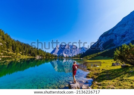 woman enjoying beauty of nature looking at mountain. Adventure travel, Europe. Woman stands on background with Alps. Royalty-Free Stock Photo #2136226717