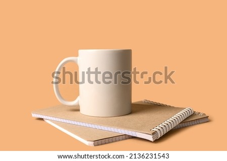Two notebooks and a ceramic white mug. Minimalistic layout for design. The concept of work at home.