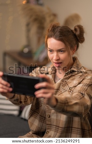 Player plays on portable console, young girl with smile plays on portable console.Concept of cyberprot, entertainment for children, computer games