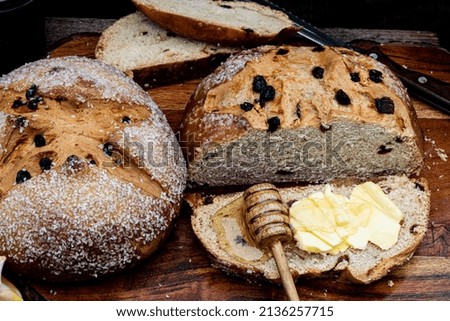 sliced round loaf of Irish soda bread with slice spread with butter and honey Royalty-Free Stock Photo #2136257715