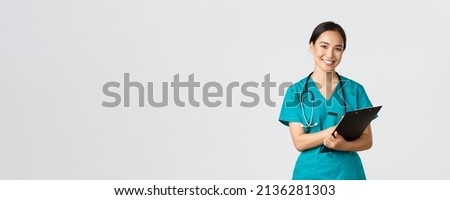 Healthcare workers, preventing virus, quarantine campaign concept. Cheerful friendly asian female physician, doctor with clipboard during daily checkup, standing white background