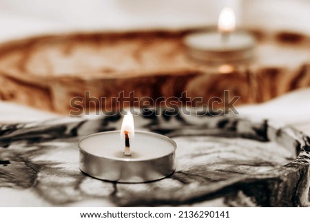 Gypsum marble decorative stand with candles on the background of silk stand.
