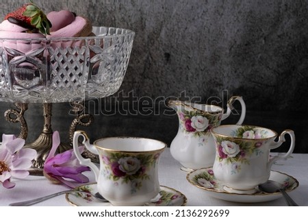 Coffee mug with cupcake, flowers, newspaper and notes good morning on rustic table, sweet dessert for breakfast, lifestyle