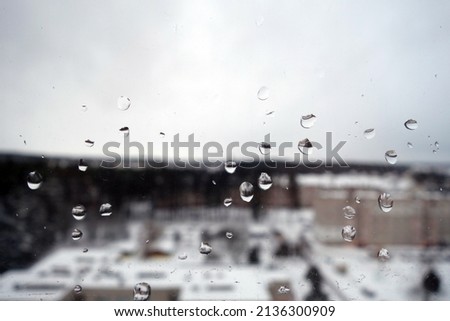 View from window with rain drops and snow. Abstract blur background                                       