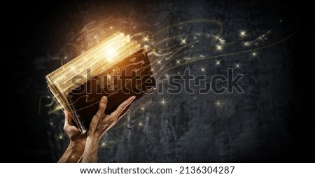 Opening a magical antique book Royalty-Free Stock Photo #2136304287