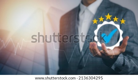 Quality assurance of business services, Businessman Hand shows the sign of the top service Quality assurance in Black background , Guarantee, Standards, ISO certification and standardization concept. Royalty-Free Stock Photo #2136304295